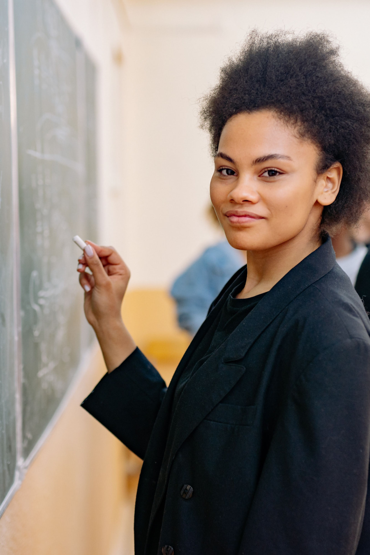 A teacher writing on a classroom board