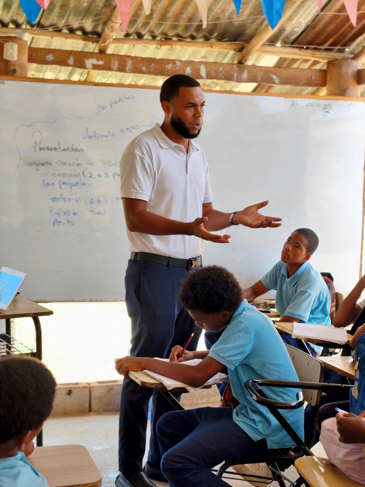 A teacher speaking with pupils in a classroom